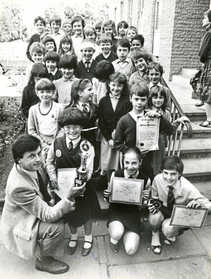 1985 - Accident prevention officer Bill Duncan presents the divisional winners of the Grampian road safety competition trophy to Rachel Mair. Looking on are other members of the Banchory Primary team.