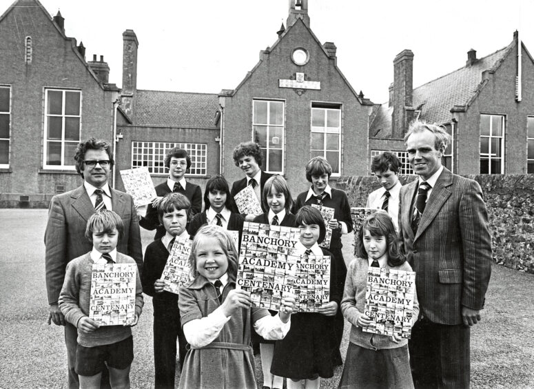 1978 - Primary 3 pupil Fiona Wink shows off the school’s centenary magazine watched by pupils from most of the other classes in both primary and secondary schools.