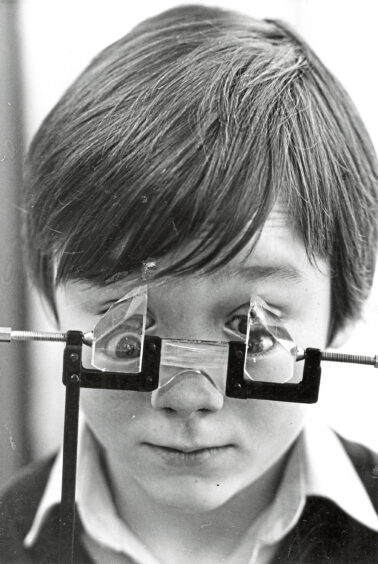 A boy looking through a pair of prism glasses