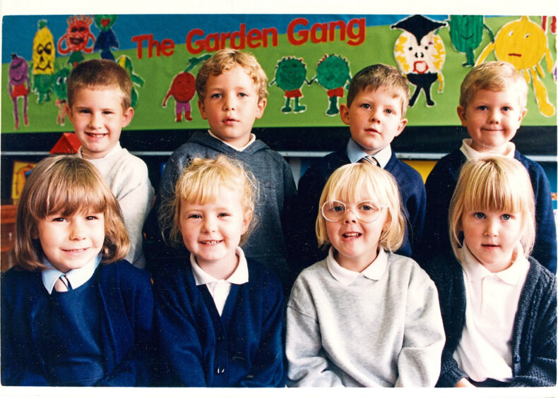 Eight pupils standing in two rows smiling at the camera