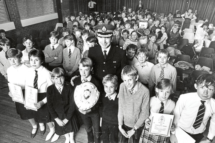 A policeman standing with school pupils