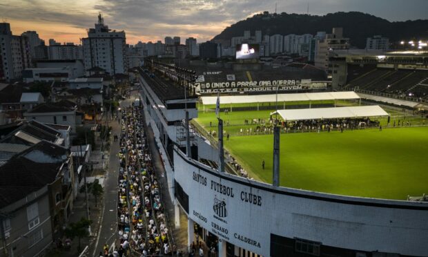 People wait in line to enter Vila Belmiro stadium in Santos, Brazil, where Pele - the late football great - was lying in state. Image: AP