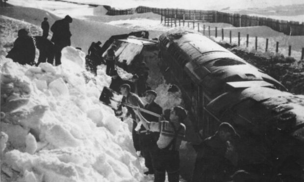 Men working to dig out a stranded train on the line at Dava Moor on February 9 1963 where the line was blocked for 1¼ miles to a maximum depth of 30ft.