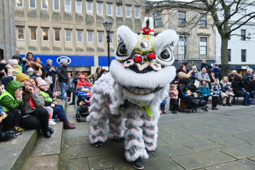 White dragon from the parade dancing around on the Plainstones in Elgin