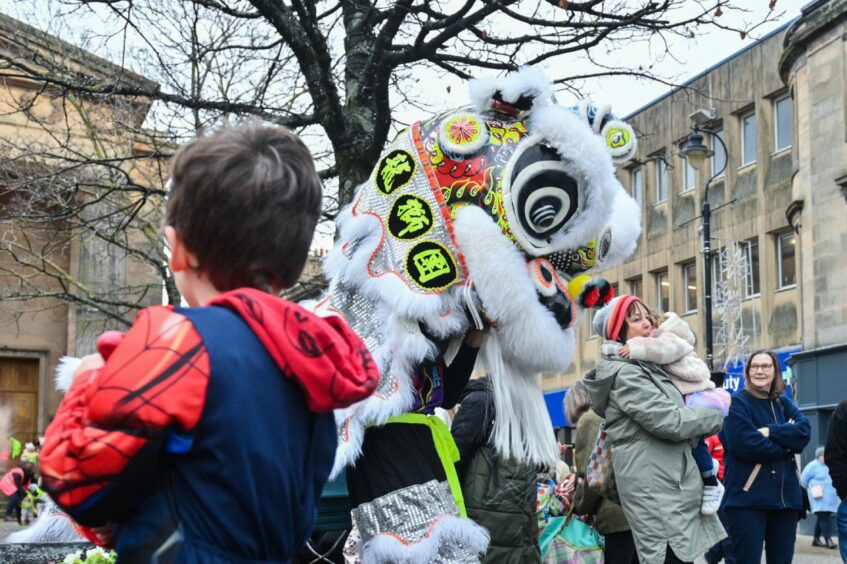 White dragon going up to people watching the Chinese New Year parade in Elgin