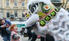 Child looking in awe up at dragon from Chinese New Year parade in Elgin
