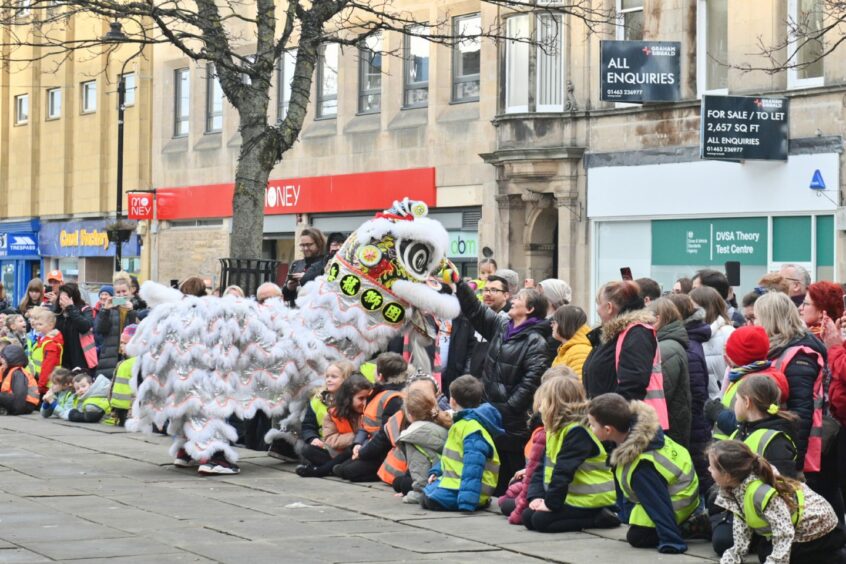 Dragon running towards the spectators watching the Chinese New Year parade in Elgin
