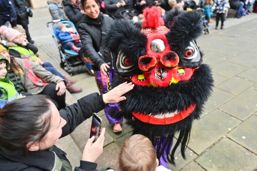 Black dragon being clapped by people watching the Elgin Chinese New Year performance