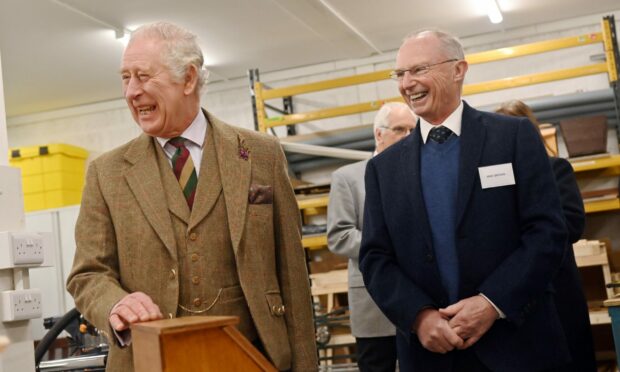 King Charles stands laughing during his visit to Aboyne Men's Shed