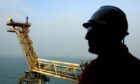A worker in a hard hat looks out over gas processing complex on the South Morecambe field in the Irish Sea