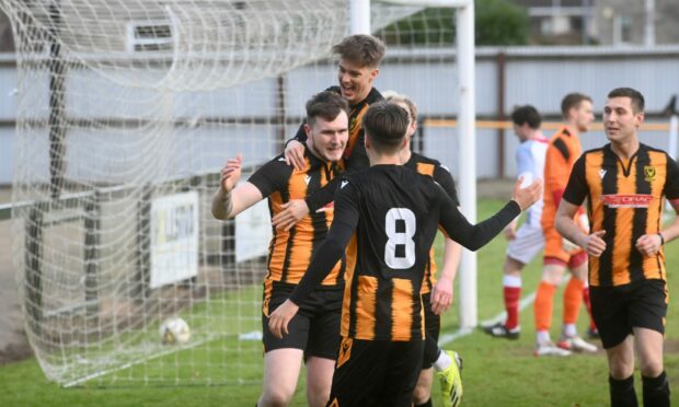 Huntly goalscorer Kyle Dalling, left, is mobbed by his team-mates after scoring their first against Turriff United