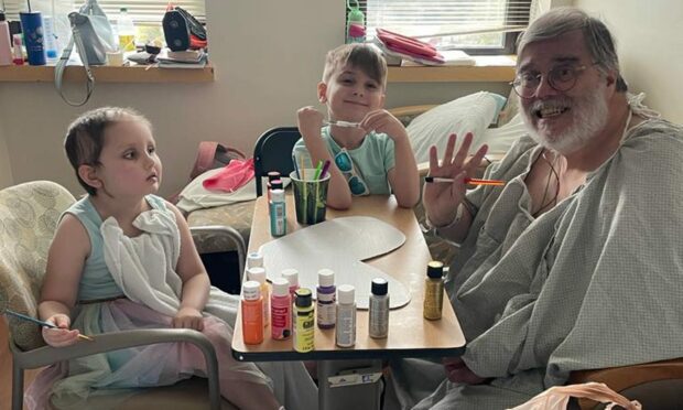 Hugh Drysdale in hospital after having a heart attack and stroke with his grandaughter Kyla and grandson Kaydn. USA. Image: Hugh Drysdale.