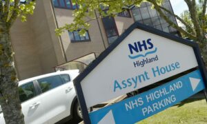 The signs outside NHS HIghland headquarters at Assynt House in Inverness. They are white with blue writing. It reads NHS HIghland, Assynt House, NHS Highland parking.