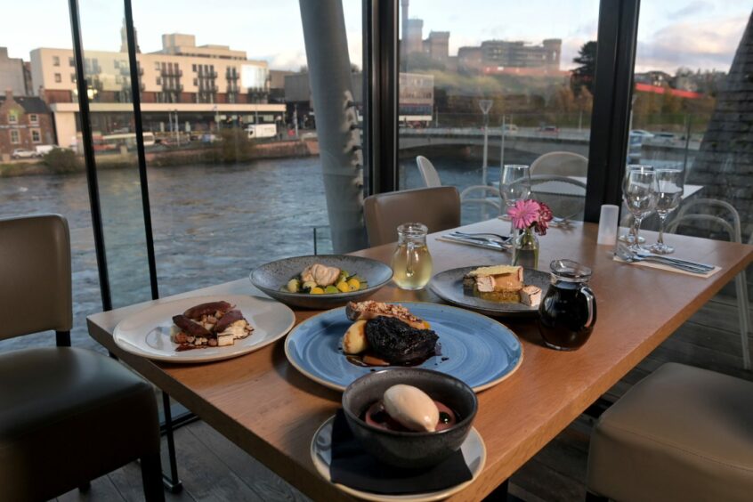A table of food next to the window overlooking the river