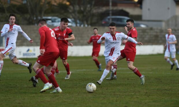 Brechin City's Anthony McDonald, in white, runs at the Lossiemouth defence. Picture by Sandy McCook
