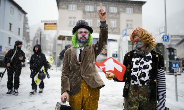 Two men made up as clowns attend a demonstration against the annual meeting of the World Economic Forum in Davos, Switzerland. Image: AP Photo/Markus Schreiber.
