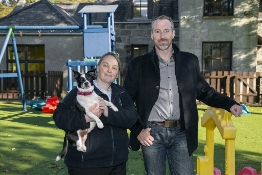 Terry Wiseman, manager of Banana Moon Nursery, pictured with Will Hanekom, pastor of Oasis Christian Fellowship Church, and the nursery dog Hilda.