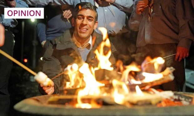 Prime Minister Rishi Sunak toasts marshmallows during a visit to the Sea Scouts community group in Muirtown, near Inverness (Image: Andrew Milligan/AP/Shutterstock)