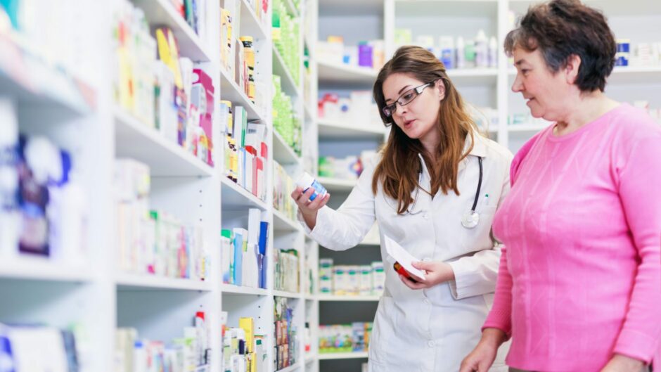 Female pharmacist discusses prescription medication with customer