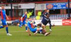 Caley Thistle defender Danny Devine brings down Zach Robinson for a penalty. Image: SNS