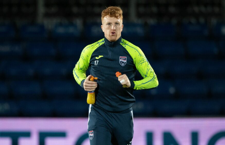 Simon Murray jogging with a bottle of juice in his hand