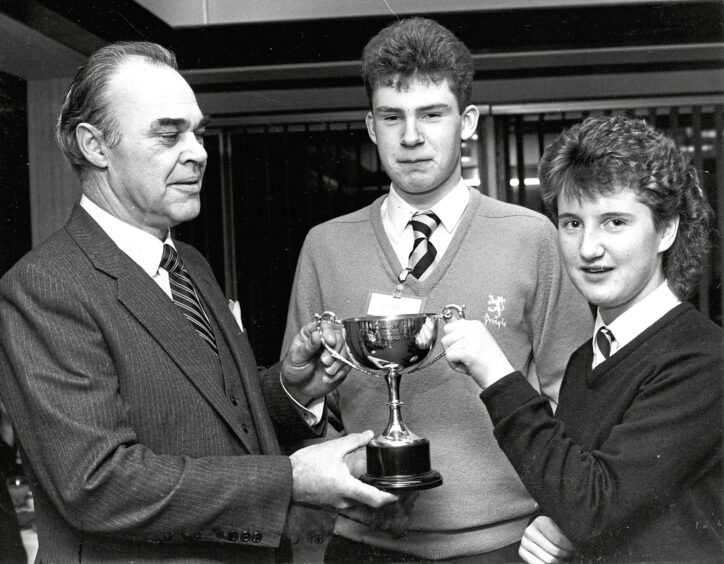 1987 - Banff Academy's Norman Meldrum and Fiona McWhirr receive the Gateway Cup for the best novice team from Mr George Oliphant, Aberdeen manager of Gateway Building Society.