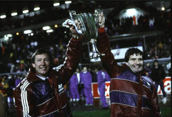 Aberdeen assistant manager Archie Knox (right) and manager Alex Ferguson hold up the European Cup Winners' Cup after beating Real Madrid in the final in 1983. Image: SNS.