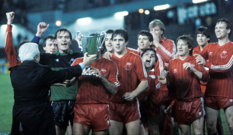 Jim Leighton and his team-mates are ready to celebrate as Aberdeen skipper Willie Miller is presented with the trophy in Gothenburg.