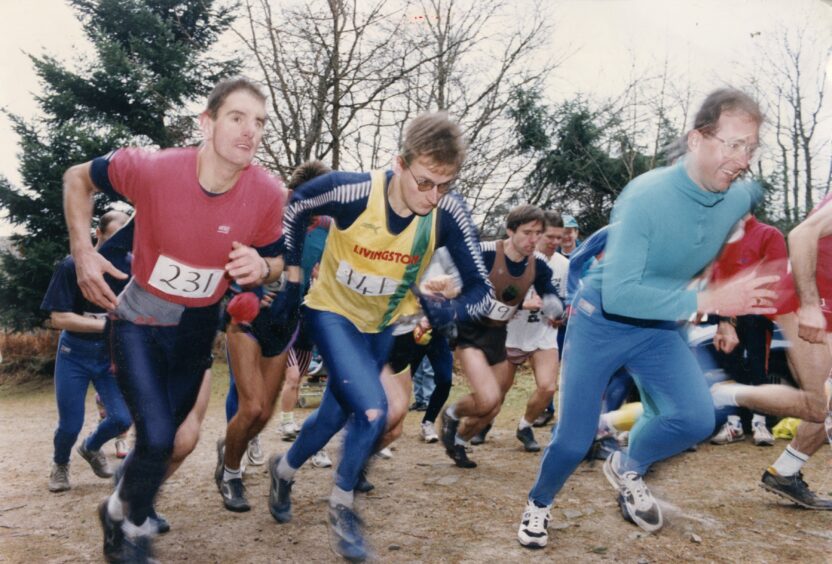 A coloured photo of men starting to run in a forest