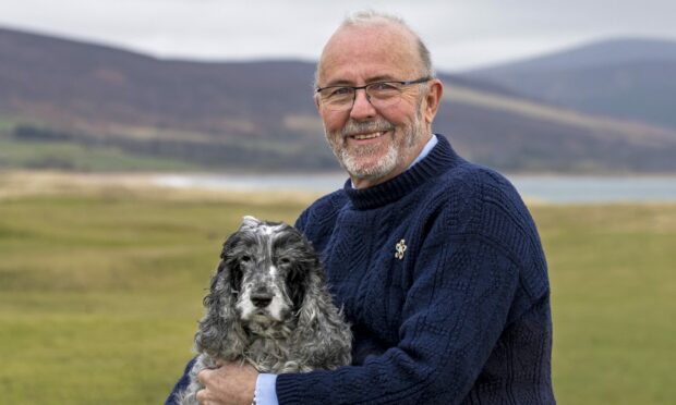 Guy Crawford holding his dog Misty, a Blue Rowan cocker spaniel