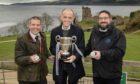 Camanachd Association president Steven MacKenzie; award-winning fiddle player Duncan Chisholm and Highland Industrial Supplies director Garry MacKintosh following the Highland Industrial Supplies Sutherland Cup draw at Urquhart Castle. Image: Neil G Paterson