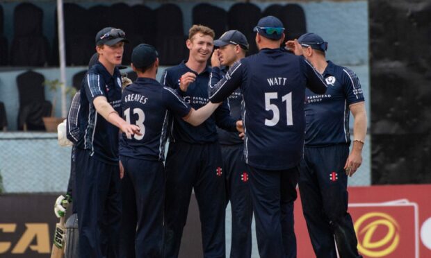 Scotland players congratulate Brandon McMullen during their win over Namibia. Image: Ian Jacobs/Cricket Scotland