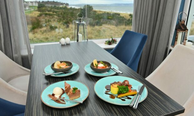 A table next to a window with four dishes on it with a gorgeous view out the window
