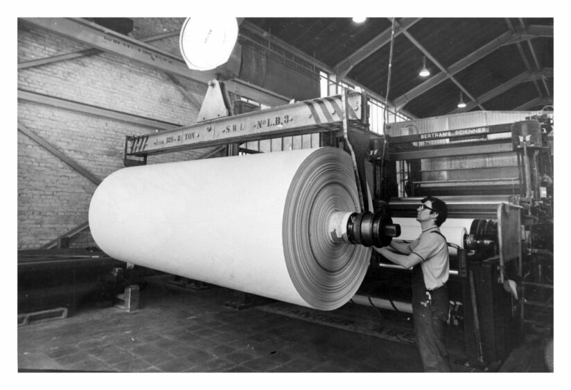 1975 - A worker handles a hefty reel at Thomas Tait and Son’s paper mill at Inverurie.
