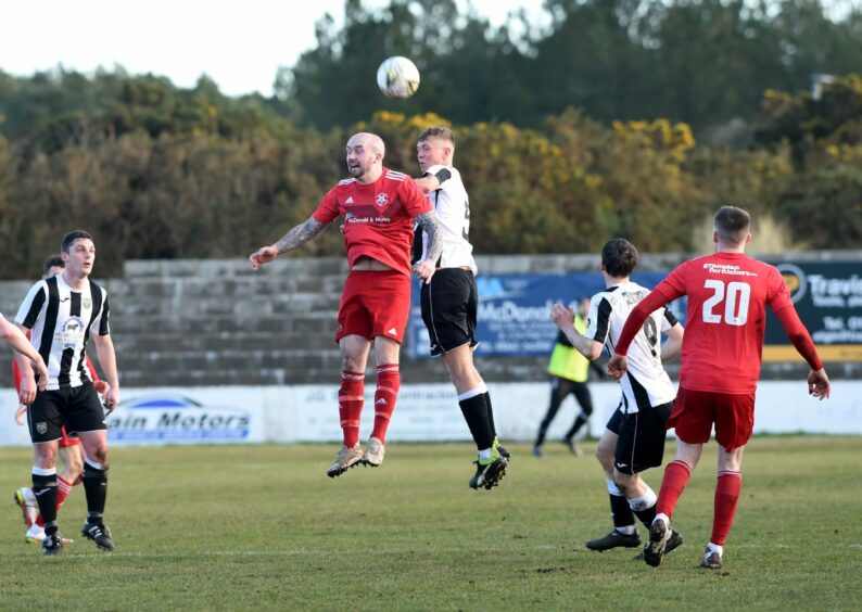 Lossiemouth's Connor Macaulay and Kieran Simpson of Fraserburgh jump for a header.