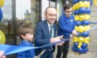 Head teacher Craig Connon cuts the ribbon along with youngest pupil Alfie Finlay (3) and oldest pupil Shon Ahmed (11) at the Ness Castle Primary grand opening