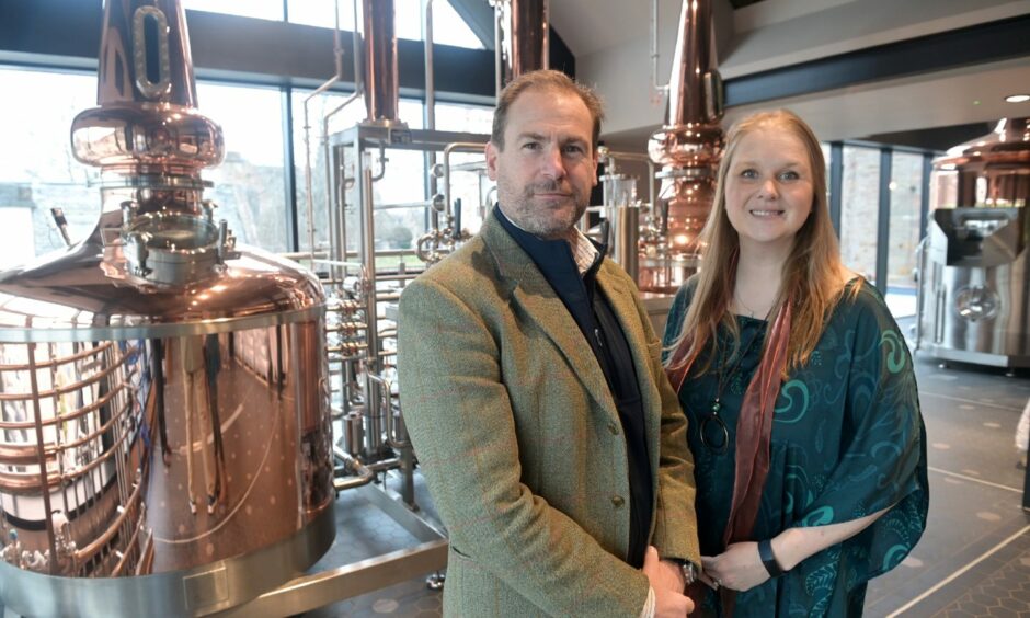 Jon and Victoria Erasmus in front of copper stills at the Uile-bheist distillery in Inverness