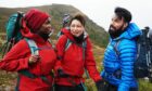 Celebrities Oti Mabuse, Emma Willis and Rylan Clark walking on their Cairngorm Mountain challenge with their rucksacks and laughing
