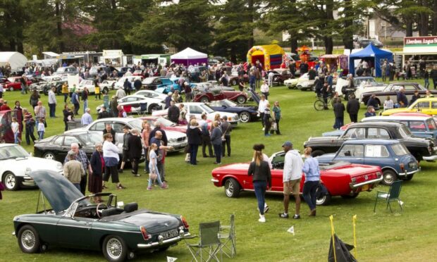 Vintage cars from Forres Theme Day lined up on the grass