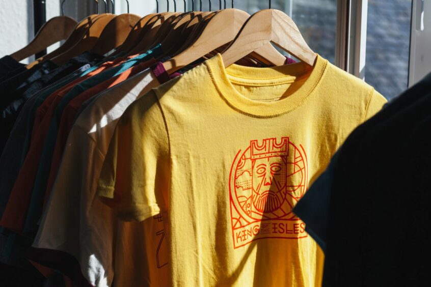 T-shirts with clean, minimalistic designs on a rack.
