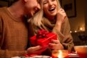 Couple exchanging gifts during a Valentine's Day at home