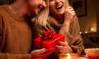 Couple exchanging gifts during a Valentine's Day at home