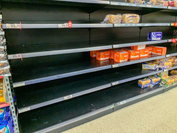 Empty supermarket shelves due to shortages.