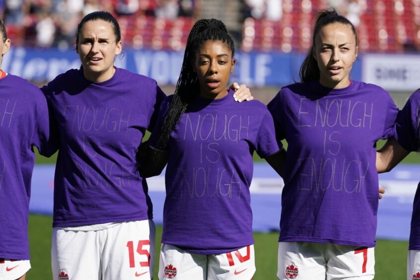 Canada's Evelyne Viens, left, Ashley Lawrence, center and Julia Grosso ( 7) wear their shirts inside out during the national anthem before a SheBelieves Cup match against Japan, in protest over equal pay. Image: LM Otero/AP/Shutterstock (13779075n)