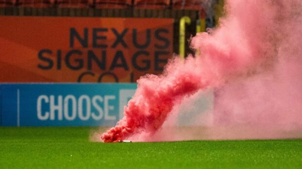 A smoke bomb is thrown on to the pitch during Aberdeen's 3-1 defeat of Dundee United. Image: SNS