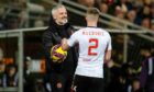 Dundee United manager Jim Goodwin hands the ball to Aberdeen's Ross McCrorie. Image: SNS