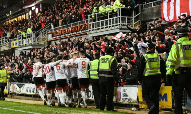 Aberdeen celebrate going 1-0 up against Dundee United with supporters. Image: SNS