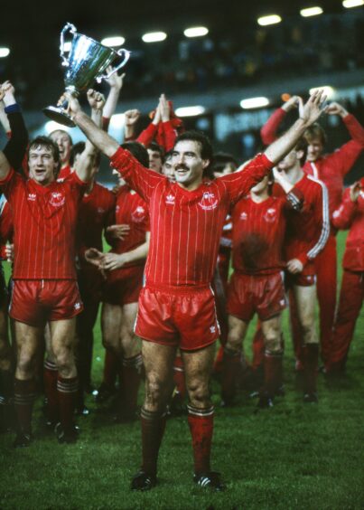 Neil Simpson, left, looks on as captain Willie Miller lifts the Cup Winners' Cup in Gothenburg. Image: Shutterstock