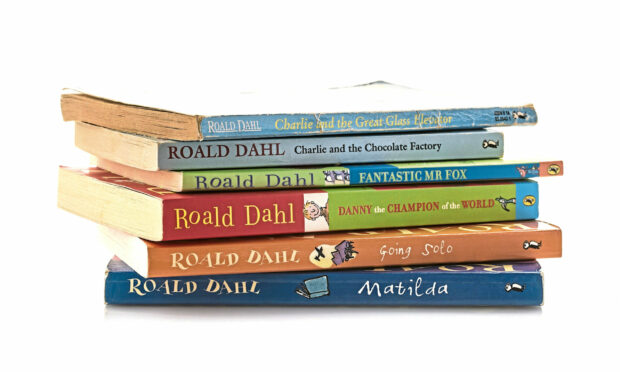 Pile of old Roald Dahl books on a white background.