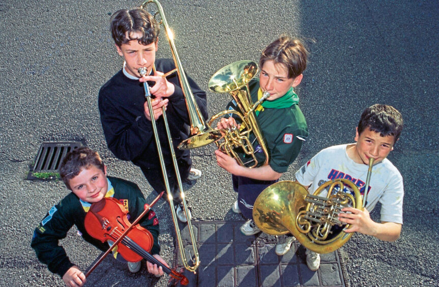 Four boys playing instruments for the gang show